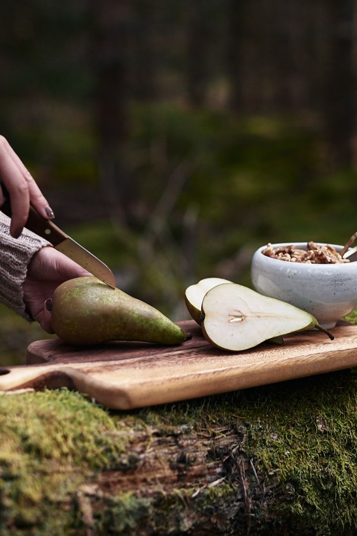 Glöggmingel i skogen där päron skärs upp på snygg skärbräda. 