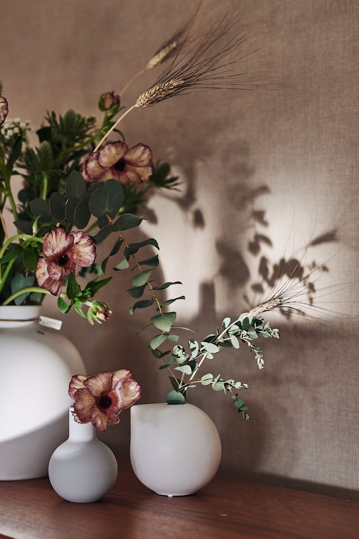 Små vaser från Cooee Design, Ernst och DBKD står på en skänk med snittblommor från Blombruket. 