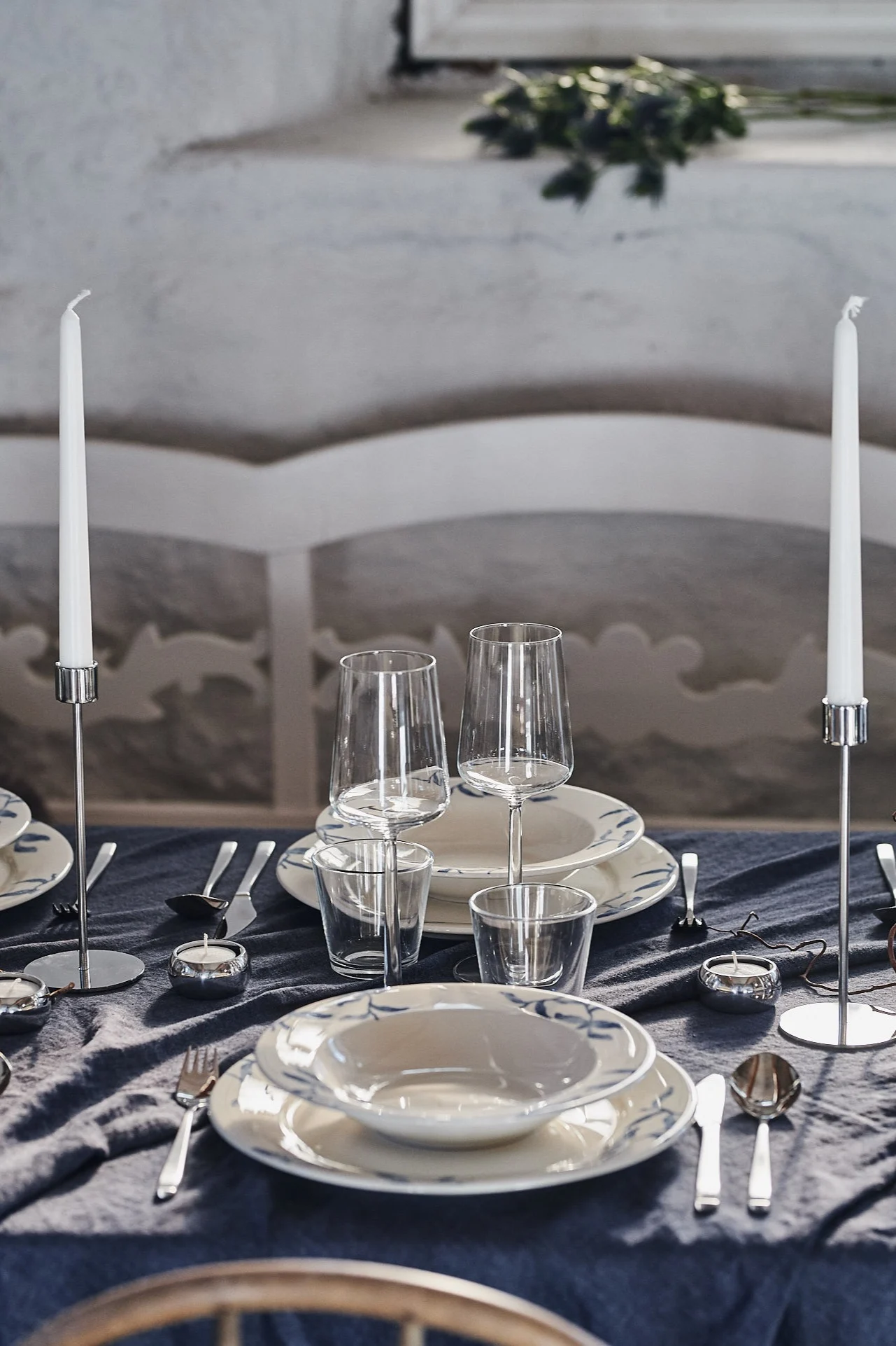 En festdukning med blåvitt porslin och Essence vinglas från Iittala i en rustik miljö.