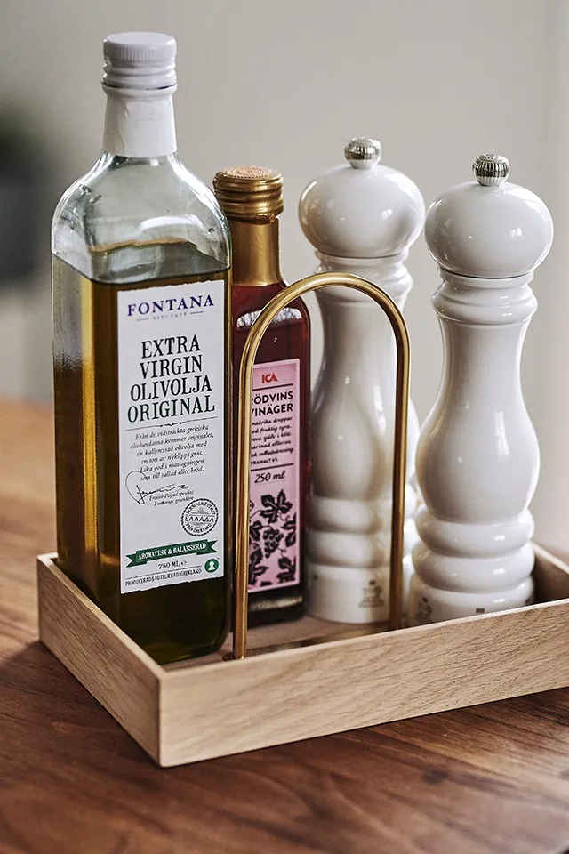 Kökets kryddor och oljor står som ett stilleben i vacker träbox från Skagerak på köksbänken.