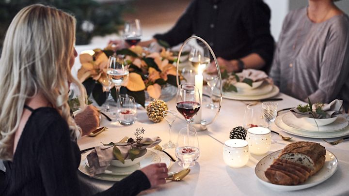 En vit, enkel juldukning med julporslin och ljuslyktor från Wik & Walsøe samt Gloria ljusstake från Klong. 