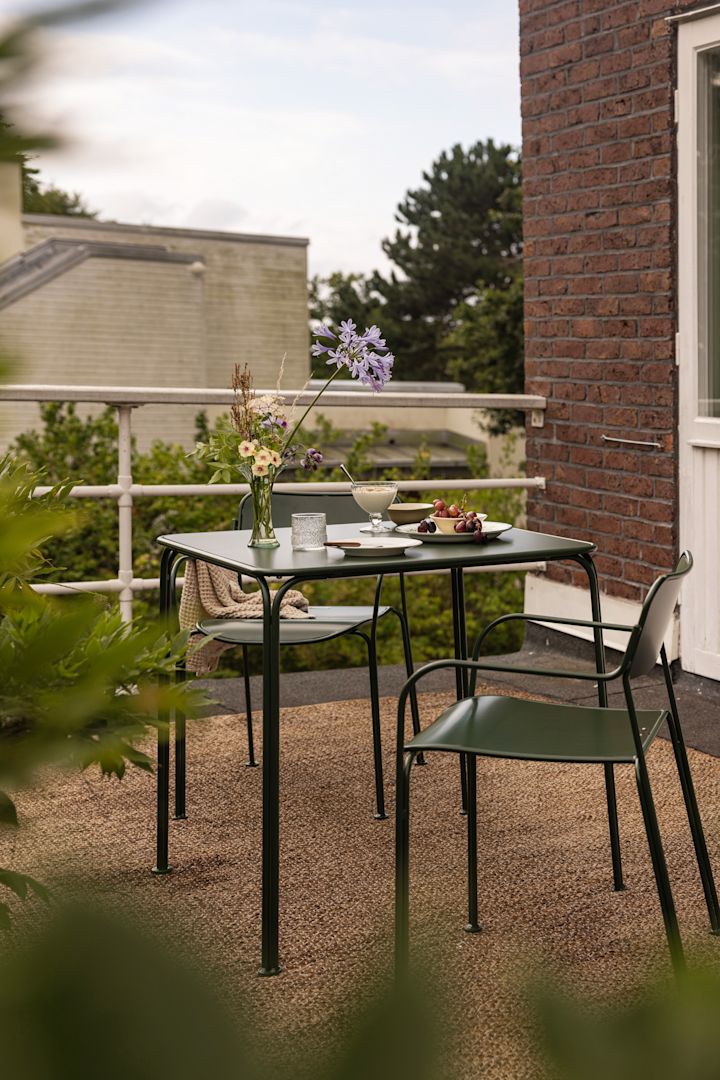 På en balkong står ett bord och två stolar från kollektionen Libelle från Grythyttan.