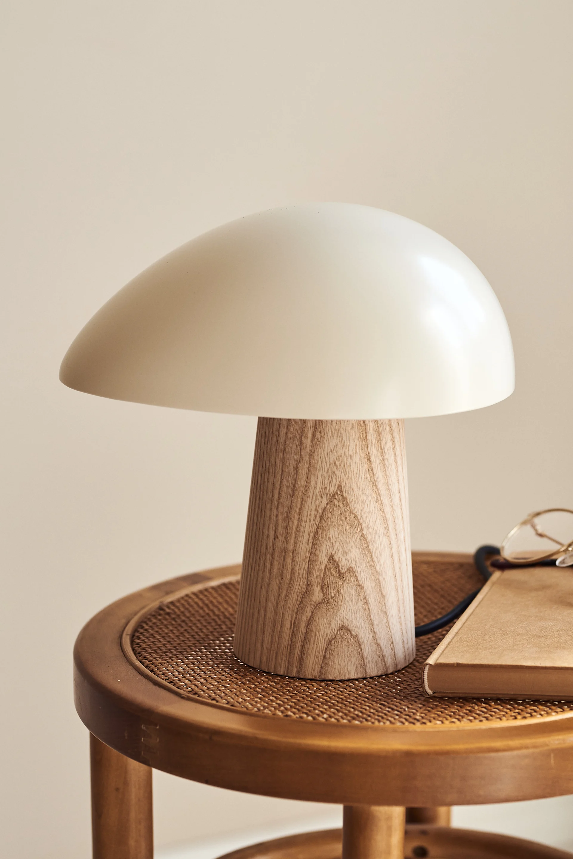 Fritz Hansens bordslampa Night Owl i ek och vitt på ett sidobord. 