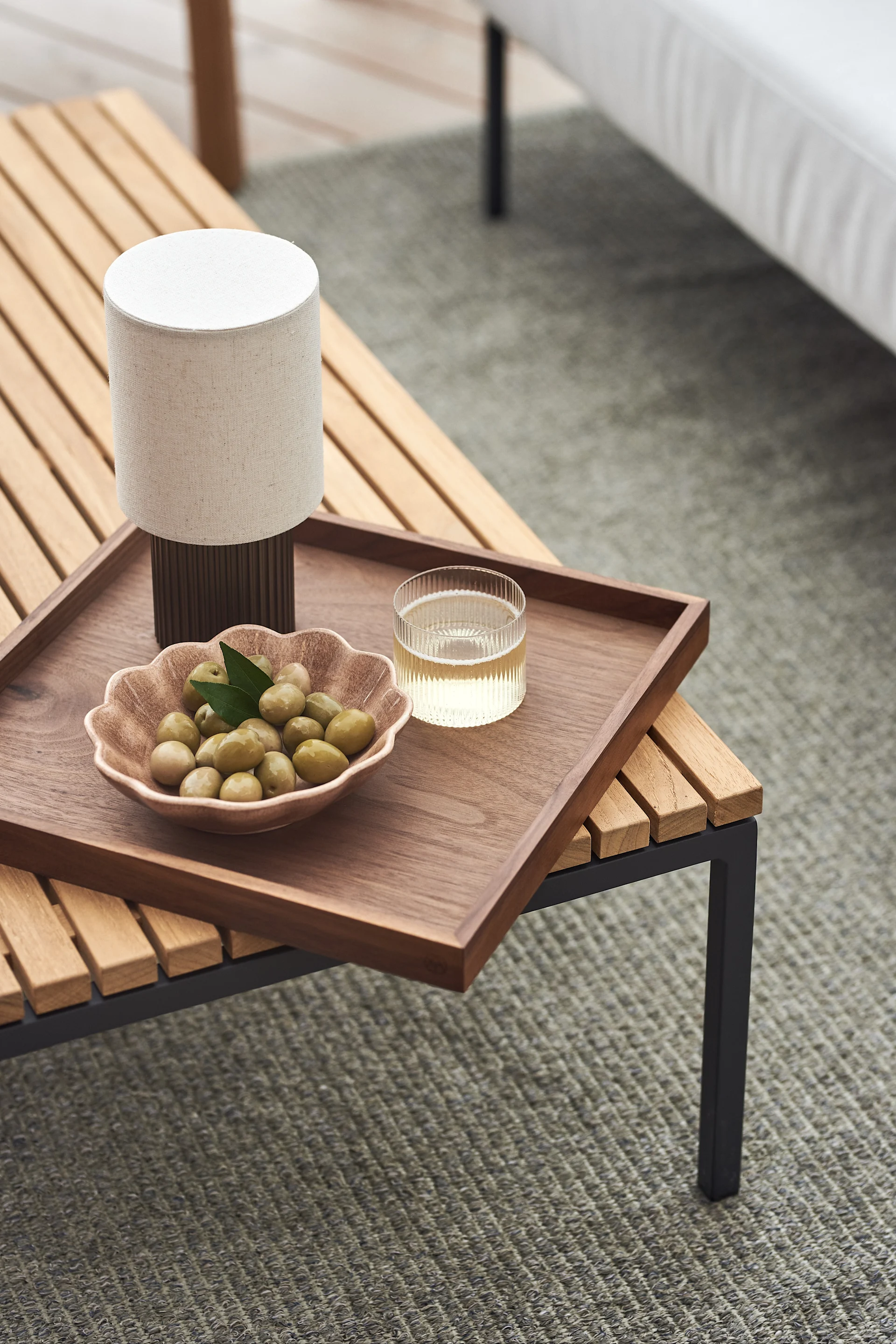 Balkonginspo med fokus på belysning, här den portabla lampan Manhattan från &Tradition placerad på uteplats.