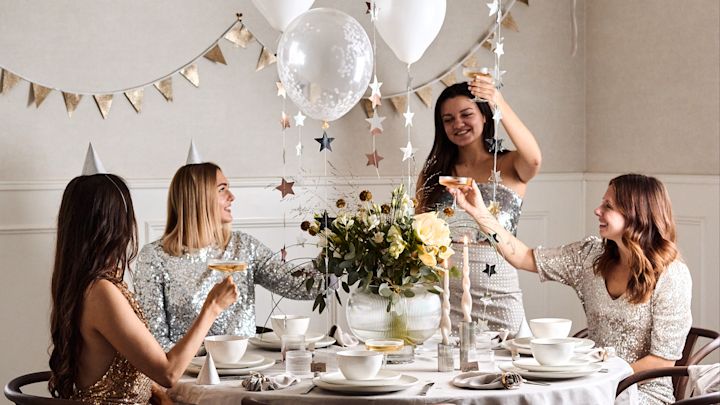 Årets nyårsdukning 2022 är en pampig sådan med stjärngirlanger, ballonger, partyhattar och med detaljer i guld och silver.