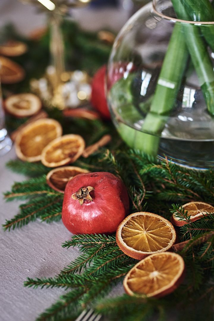 Dukning med granris, torkade apelsinskivor och granatäpple på ett klassiskt glöggmingel.