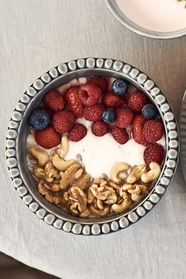 Smoothie bowl till frukost med hallon, cashewnötter, valnötter och yoghurt serverad ur djup skål från PotteryJo. 
