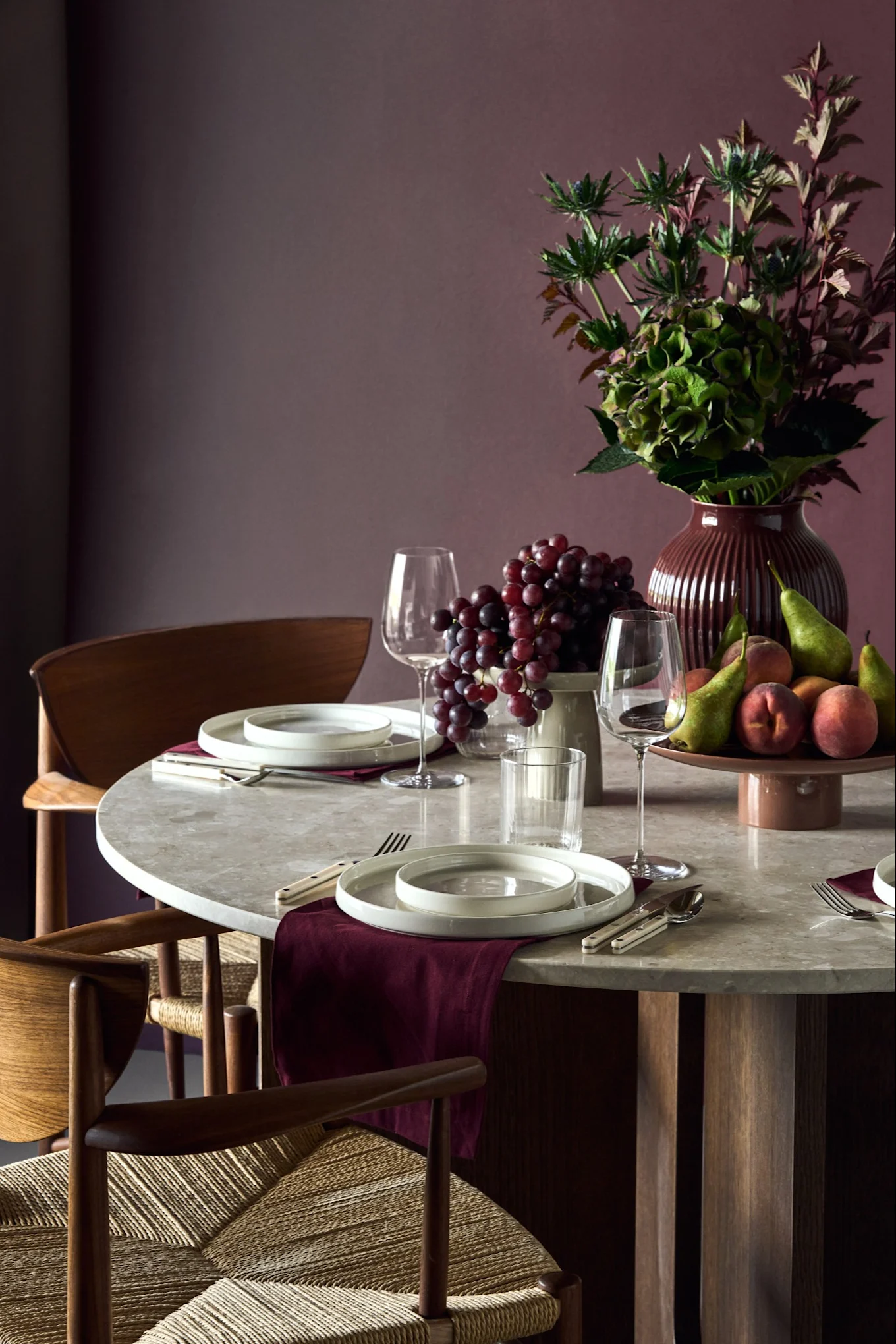 A set table with tableware and fruit in plum-toned shades, showcasing the colour trends for 2026.