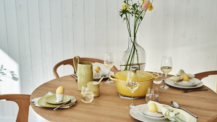 En stilfull gul påskdukning med vitt porslin men gula accenter i form av servetter, ägg och porslin. 