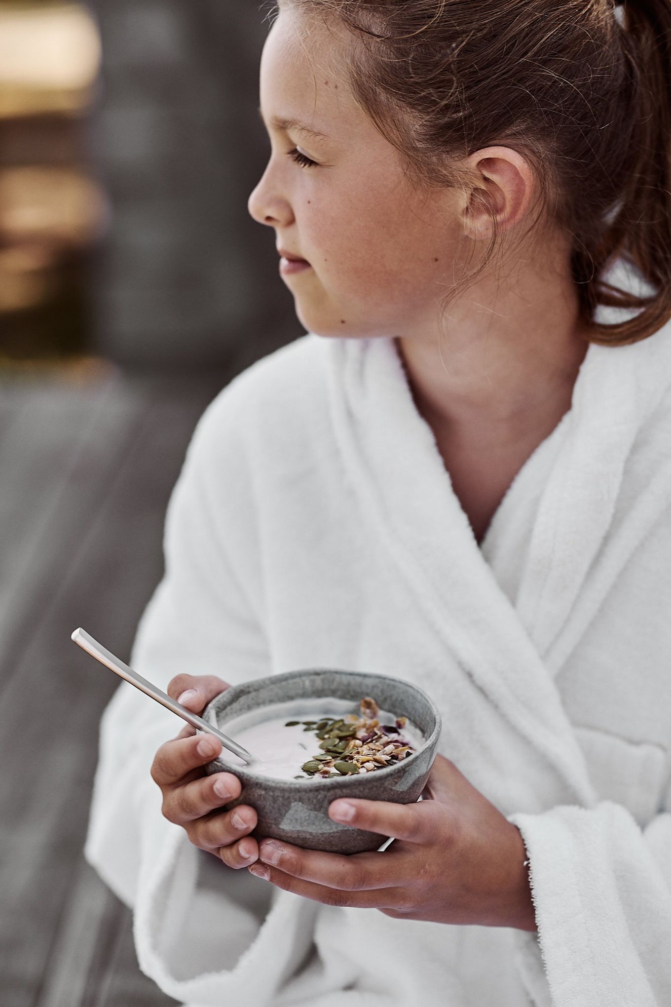 Enkel smoothie bowl med yoghurt och pumpakärnor serverad ur liten grå skål från Mateus förgyller morgonstunden. 