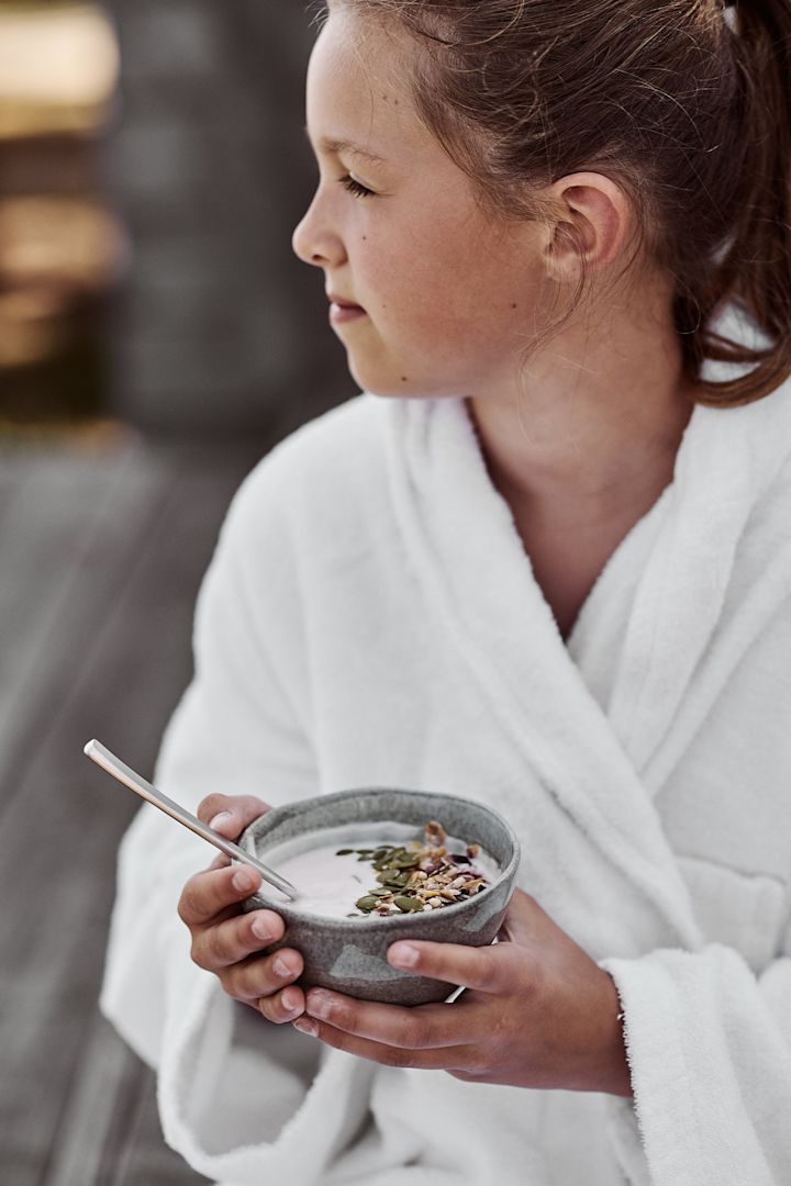 Enkel smoothie bowl med yoghurt och pumpakärnor serverad ur liten grå skål från Mateus förgyller morgonstunden. 