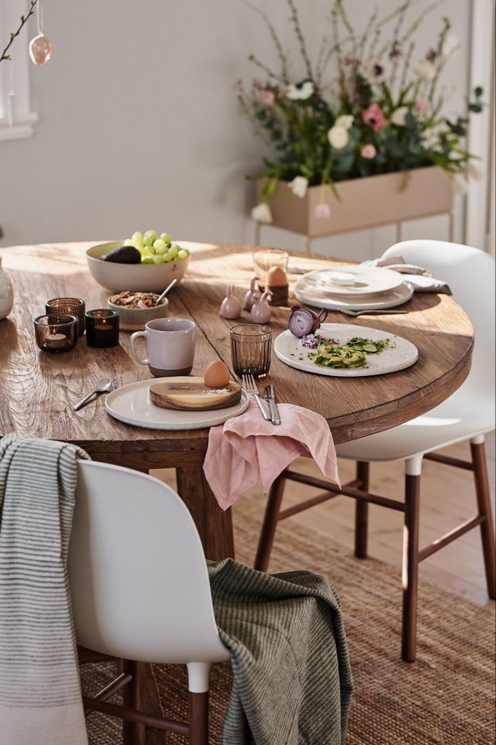 En frukostdukning med rosa linneservett från Nordic Nest ledigt lagd under tallriken – ett tips på hur man enkelt kan vika linneservetter på. 
