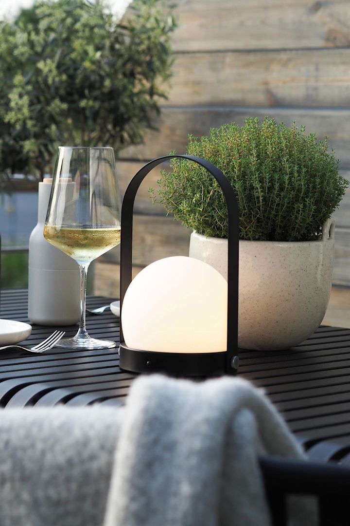 Den portabla lampan Carrie från Audo Copenhagen och blomkrukan Speckle från Ferm Living står på bordet Palissade från HAY på @wohngluecksiebens terrass.