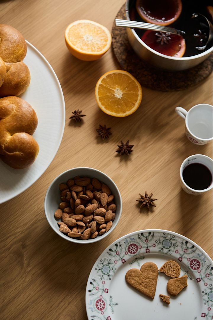 Förberedelser inför en vinterfest med saffransbullar, glögg och mandlar fotograferade uppifrån. 
