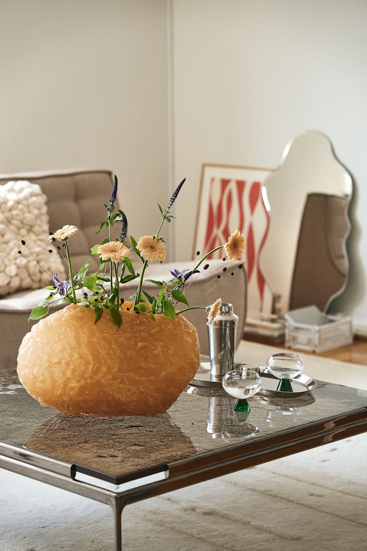 En av Byons statement pieces är Corallo-vasen som är tillverkad i handblåst glas med en tung, gedigen struktur, här i gult på soffbord med glasskiva i rökfärgat glas.