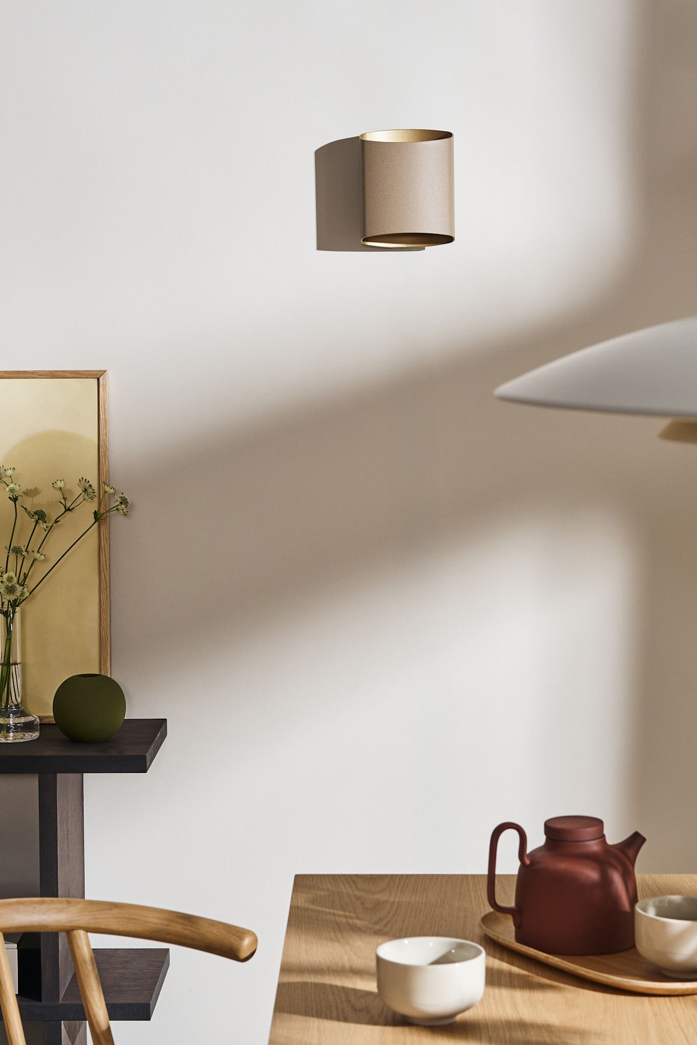 Kombinera dina belysningsidéer för matsalen med varandra, till exempel Sinne vägglampa från Belid som du ser här i beige på väggen i en matsal.