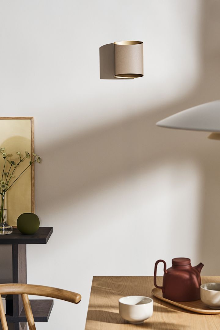 Kombinera dina belysningsidéer för matsalen med varandra, till exempel Sinne vägglampa från Belid som du ser här i beige på väggen i en matsal.