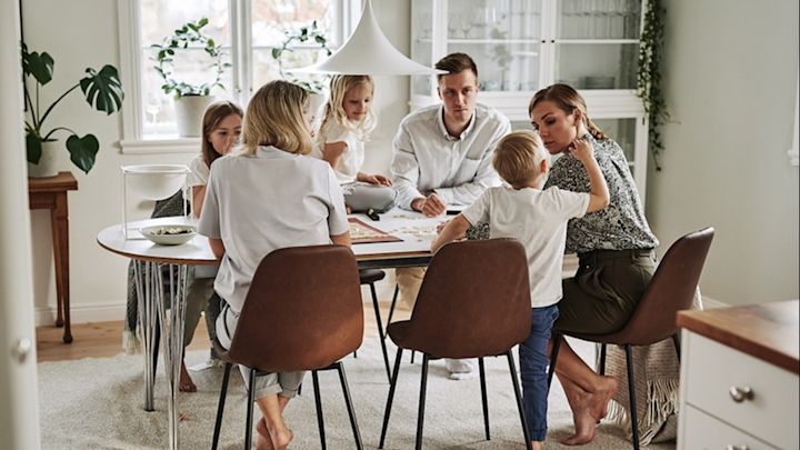 En matplats inredd i skandinavisk stil där familjen samlats för mysig spelkväll och härlig tid för hygge. 