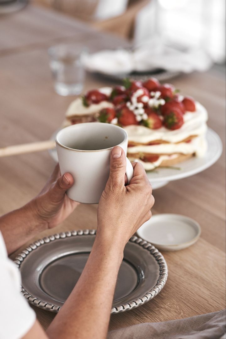 Midsommarfikat med tårta och kaffe avnjuts ur vit ERNST kaffekopp med fat & Daria desserttallrik från PotteryJo.