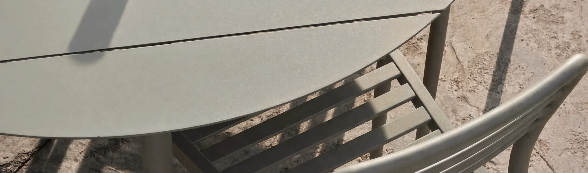 Grönt utomhusbord och stolar med vågigt design, notblad och drycker, med bambu i bakgrunden.