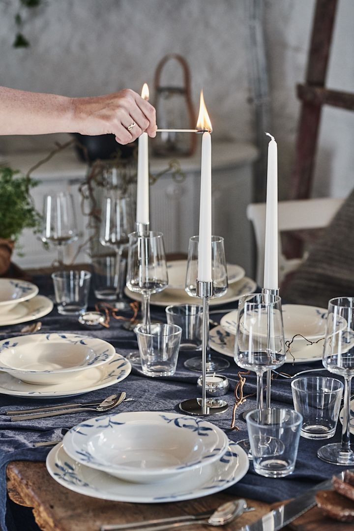 En vacker festdukning i blåvitt med höga ljus och poppande blått med hjälp av porslinsserien Havspil från Scandi Living. 