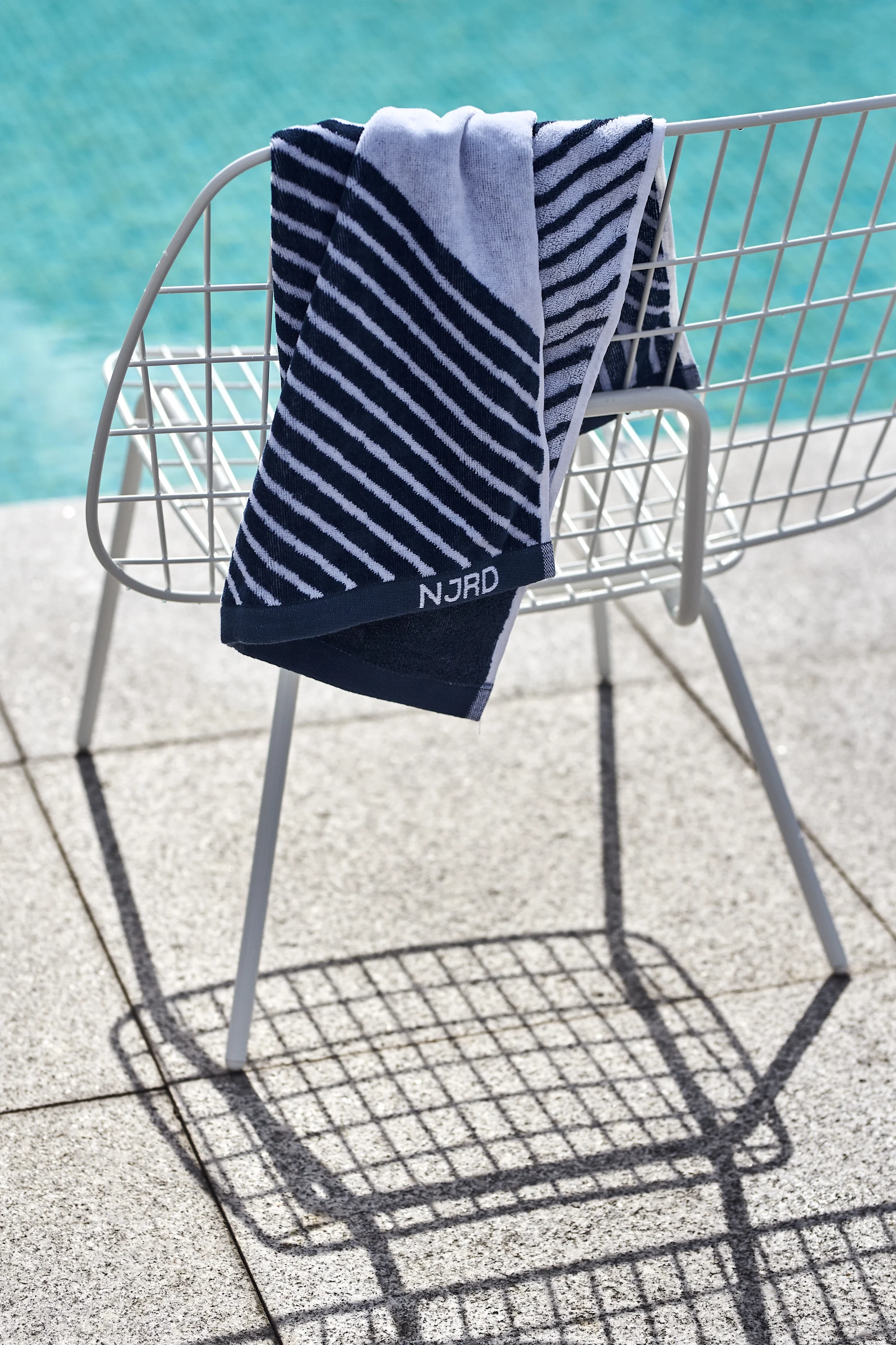 Uteplats trender 2021 - blå accenter här i form av blå handduk från NJRD och loungestol i stål från Menu.