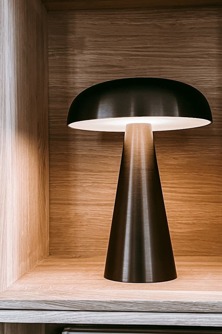 Inreda bokhyllan snyggt - inspiration hemma hos Anela Tahirovic @arkihem där en portabel lampa såsom Como från &Tradition är perfekt att styla din bokhylla med.