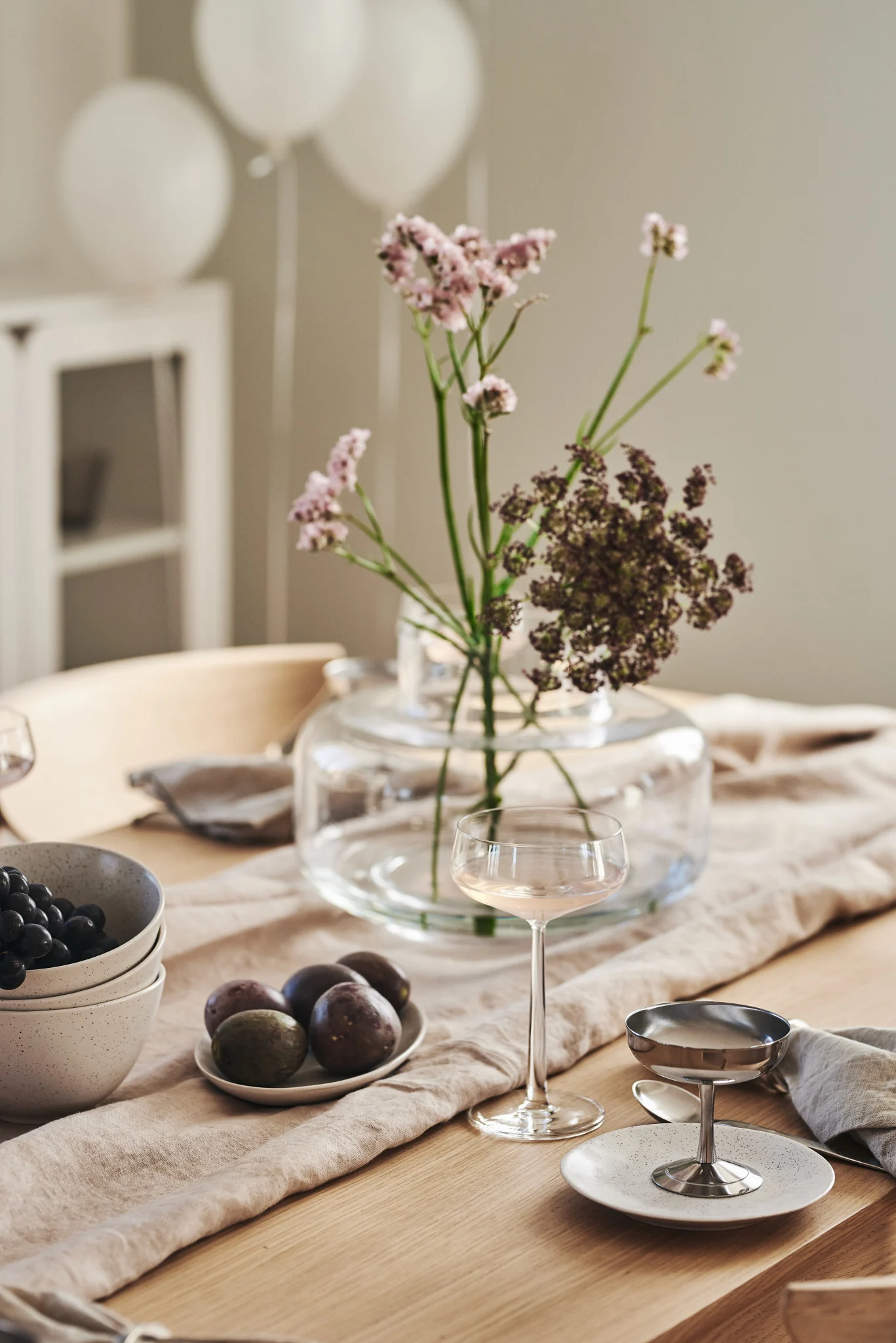 En romantisk måltid hemma går också hand i hand med rätt bordsdekorationer. Här ser du en enkel dukning med glas från Iittalas Essence-kollektion och en vas med blommor i.