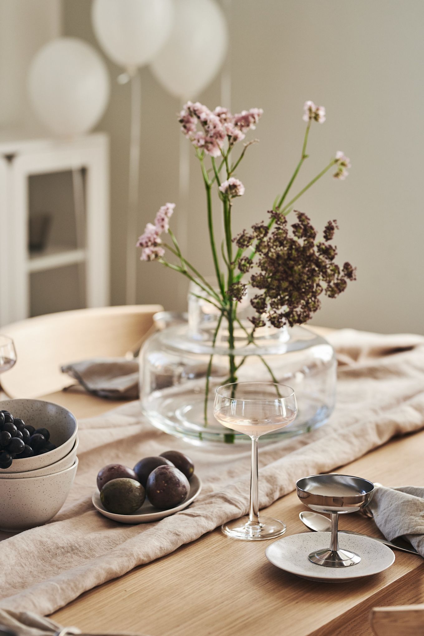 En romantisk måltid hemma går också hand i hand med rätt bordsdekorationer. Här ser du en enkel dukning med glas från Iittalas Essence-kollektion och en vas med blommor i.