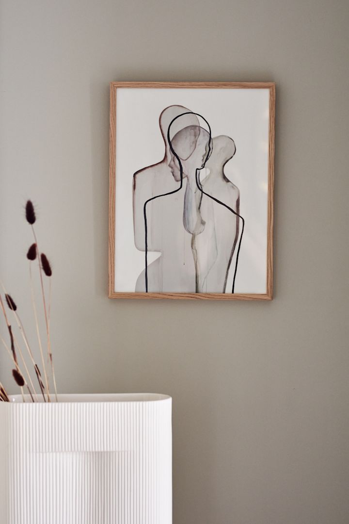 Posters är en av höstens inredningstrender 2021, här är Mother poster från Paper Collective hängandes på beige vägg bakom beige Ridge vas från Muuto.