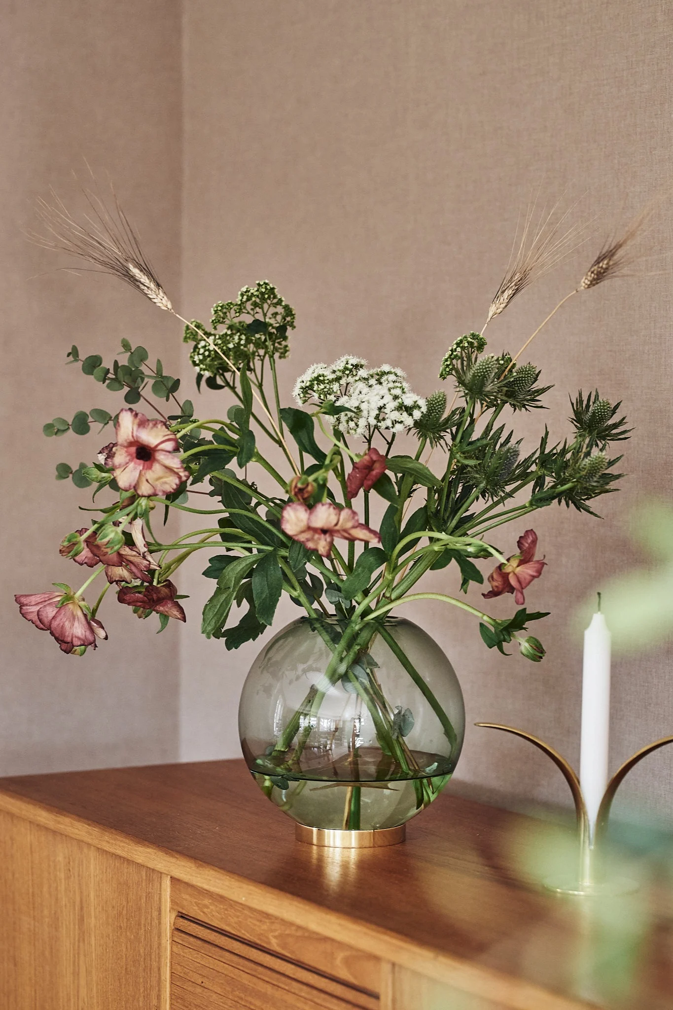 Grön, rund vas för snittblommor i grön färg från AYTM med blommor ifrån Blombruket. 