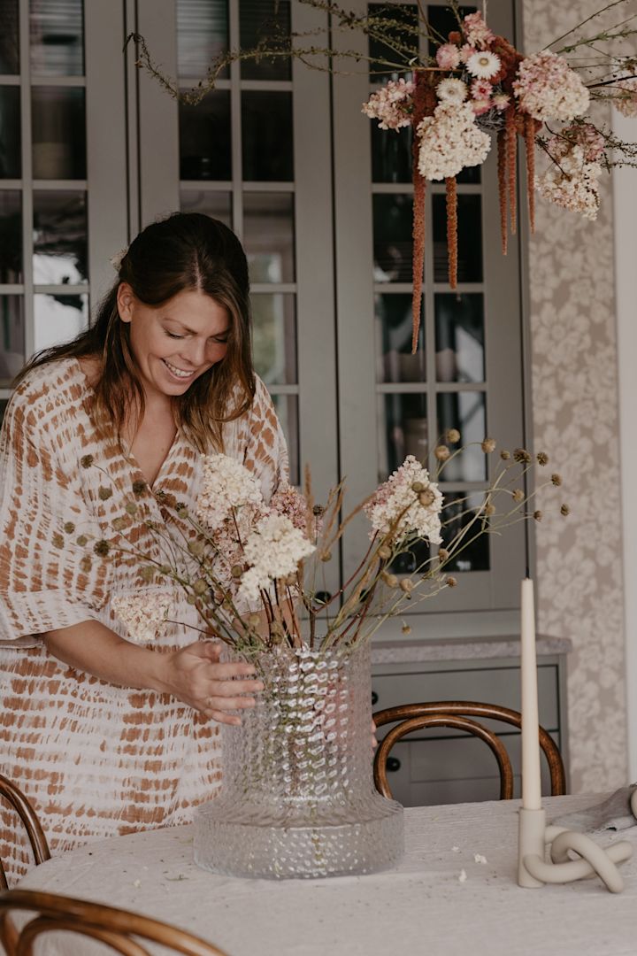 Johanna Berglund @snickargladjen sätter i torkade blommor som dekoration i Kolonn vas från Skrufs glasbruk.