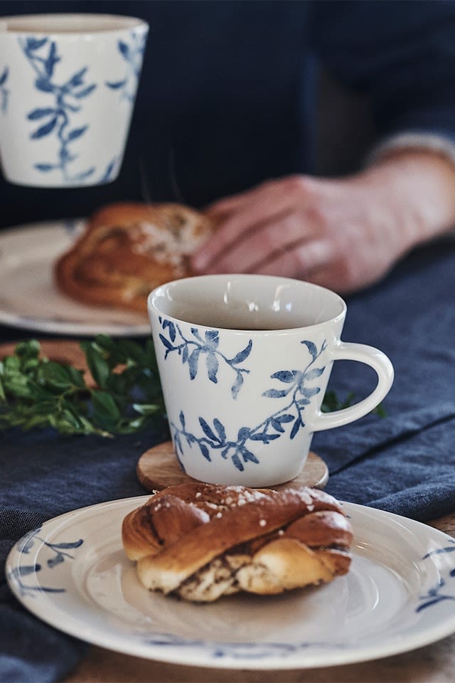 Typisk svensk fika med kaffe och kanelbulle serveras på blåvitt porslin från Scandi Living. 