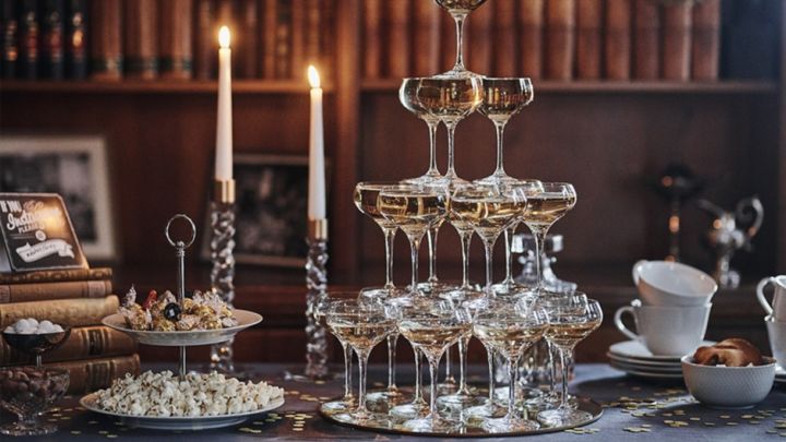 Pampigt champagnetorn med många kupade champagneglas från Orrefors och Spiegelau står som dekoration på nyårsfesten. 