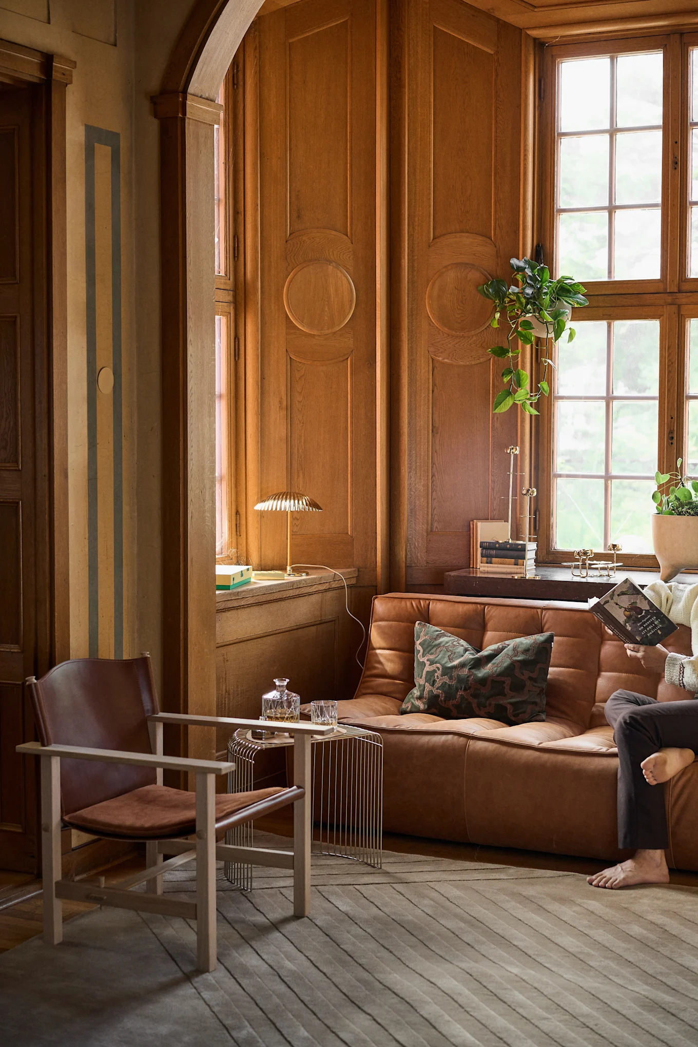 Ett rum med träpanel och brun läder soffa och fotölj som visar på 60-tals stil och inredningstrenderna 2026.