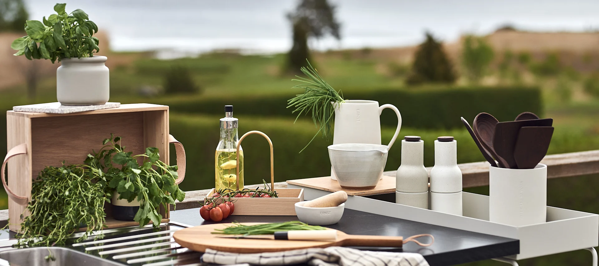 Inred ditt utekök med snygga och smarta redskap som en skärbräda, mortel, lådor att ha kryddor i eller gräslök i en fin kanna.