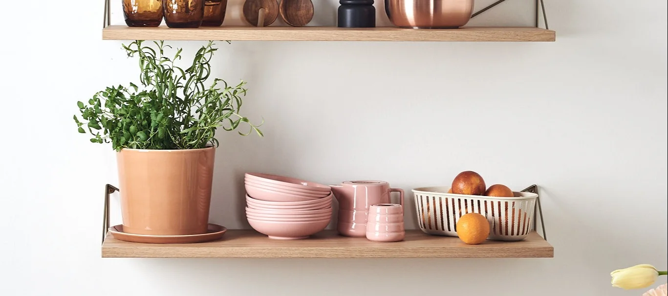 Pythagoras hylla i ek från Maze stylad med vackert porslin, kryddkvarn och kökets vardagsfavoriter.