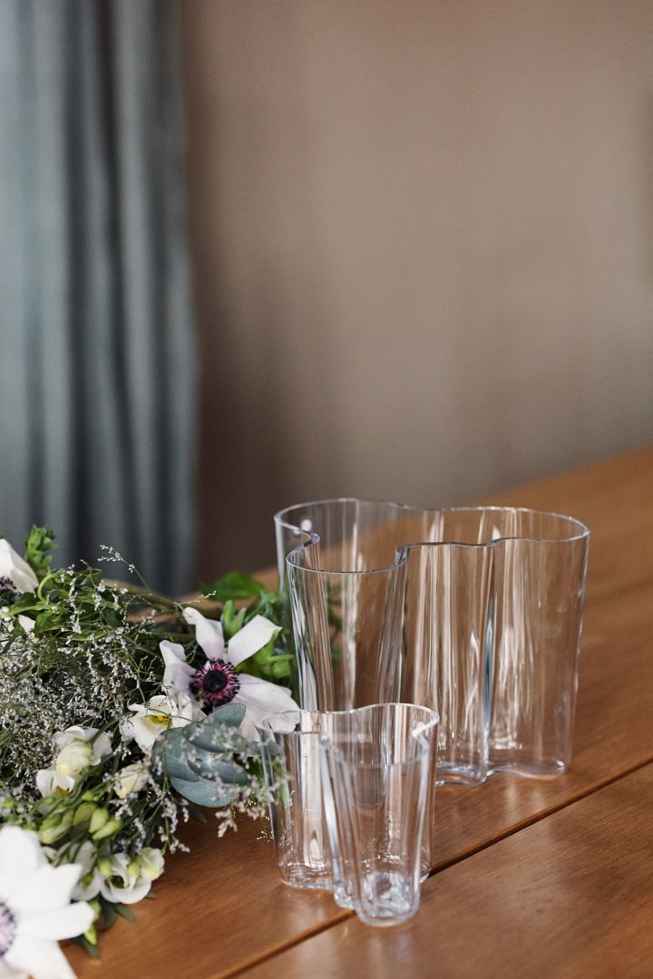 Alvar Aalto vas gåvoset i klarglas står på bordet – en tidlös skandinavisk designklassiker. 