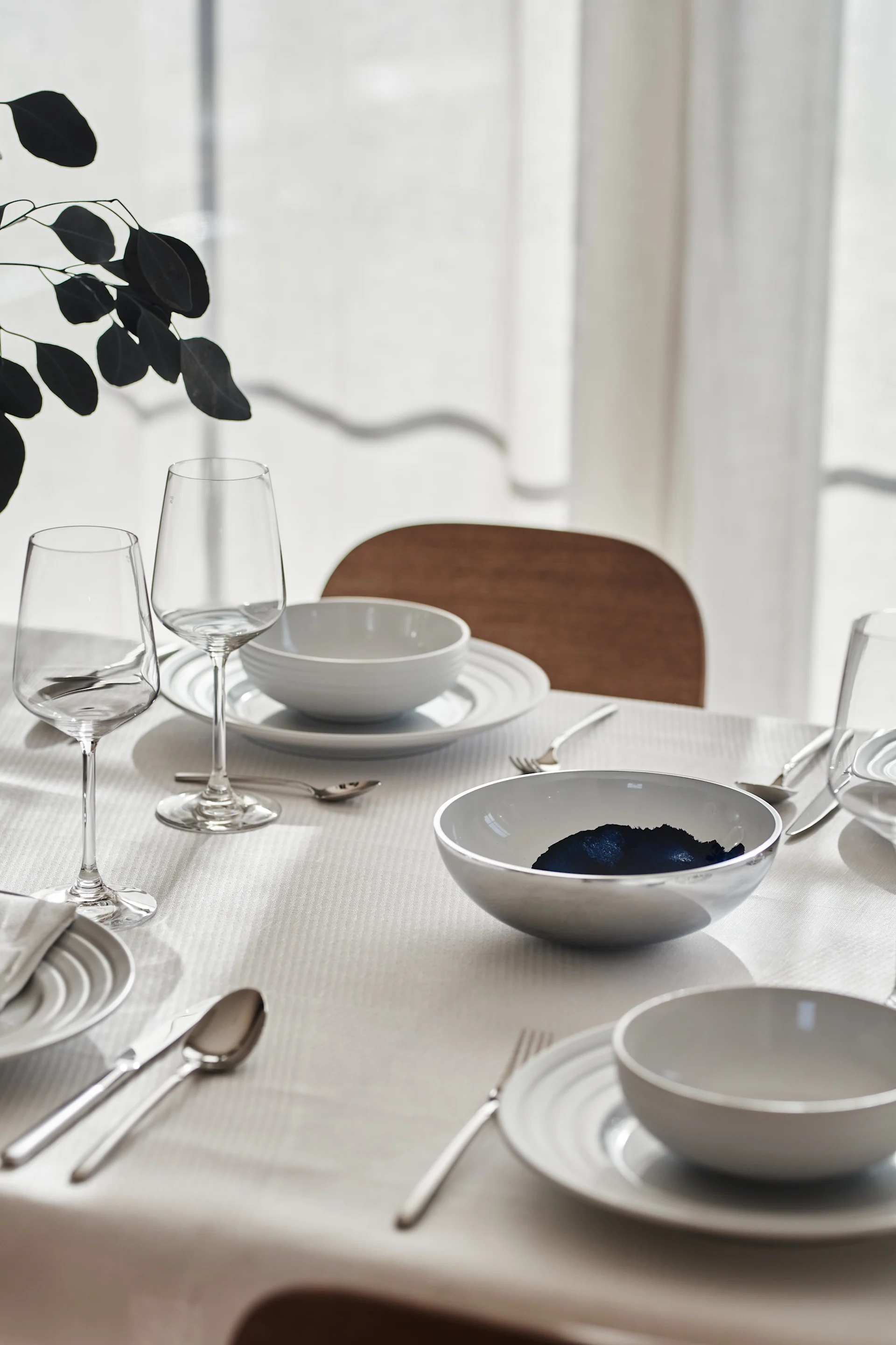 Skapa vackra festdukningar genom stilrena Scandi Living bestick, elegant Lines porslin i vitt från NJRD tillsammans med Geometric linneservetter och linneduk från NJRD i vitt.