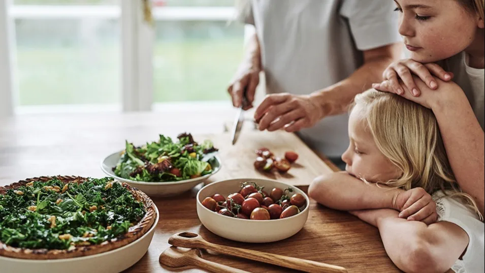 Familjens minsta ser tålmodigt på när salladen förbereds inför middagen och pajen vilar i ERNST ugnsform.