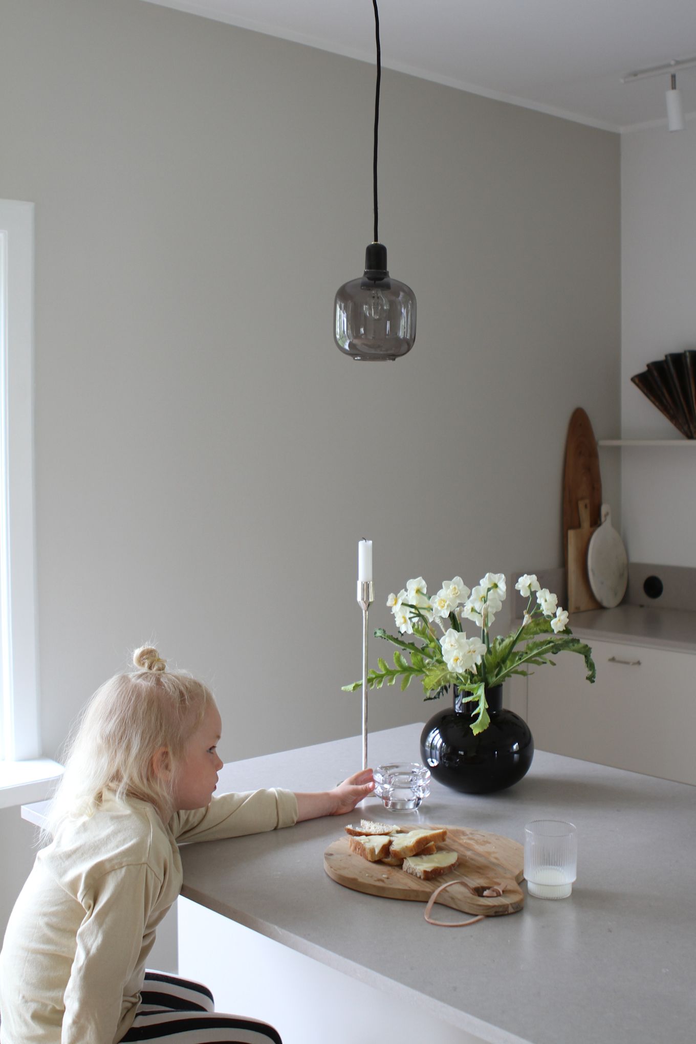 Moe of Swedens barn som sitter vid nyrenoverade köksön. Här ser du Amp lampa i grått och svart från Norrmann Copenhagen.