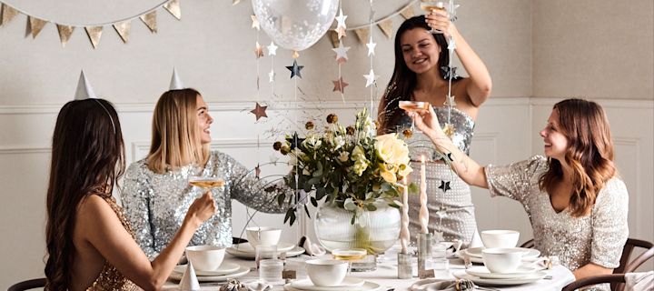Årets nyårsdukning 2022 är en festlig sådan med ballonger, girlanger, partyhattar och med detaljer i guld och silver.