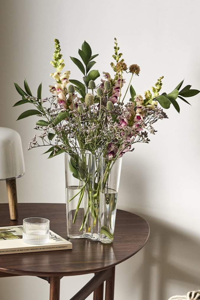 Här ser du Alvar Aalto-vasen från Iittala på sidobordet, den bäst formade vasen för blommor med långa stjälkar som liljor. 