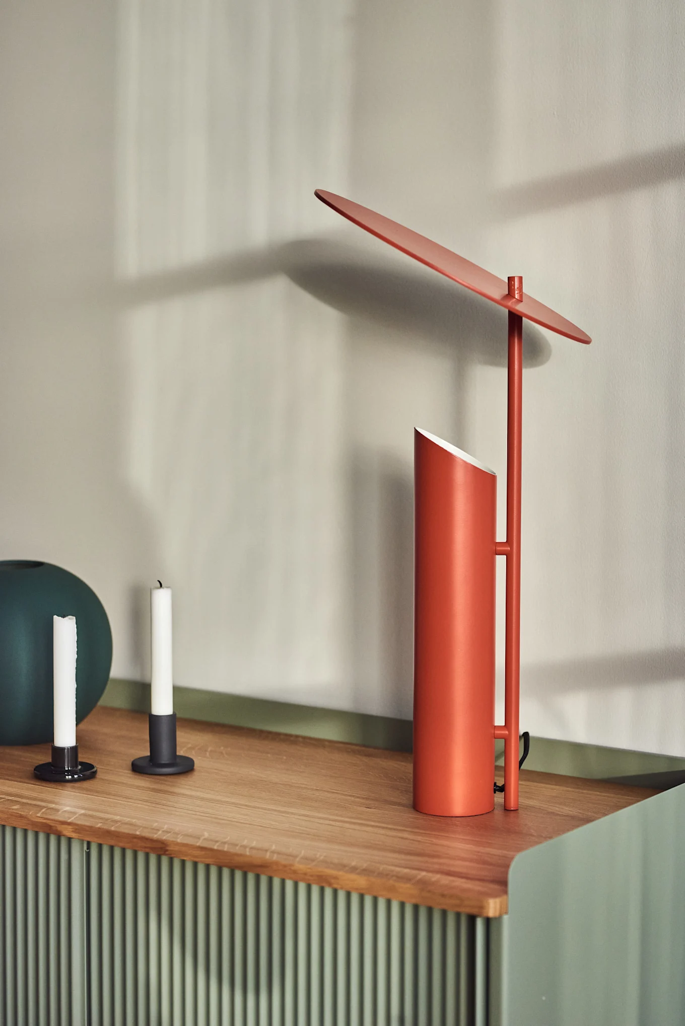 På ett sideboard står bordslampan Reflect i rött från Verpan, formgiven av Verner Panton.