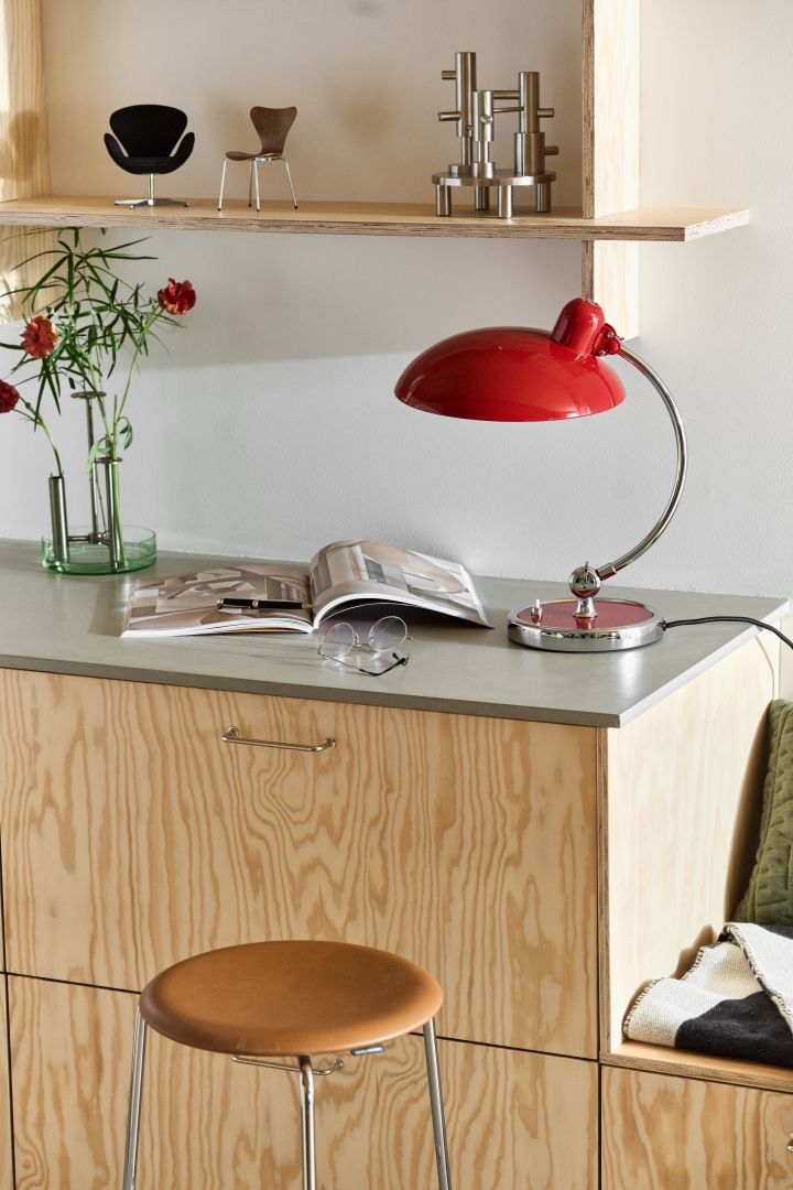 Modernt kök i plywood med barstol Dot från Fritz Hansen, Kaiser Idell bordslampa i rött och Jaime Hayon ljusstakar i rostfritt stål. 