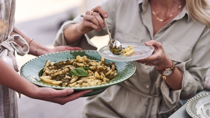 Vegetarisk pasta serveras ur grön serveringsskål från PotteryJo på trädgårdsfesten. 