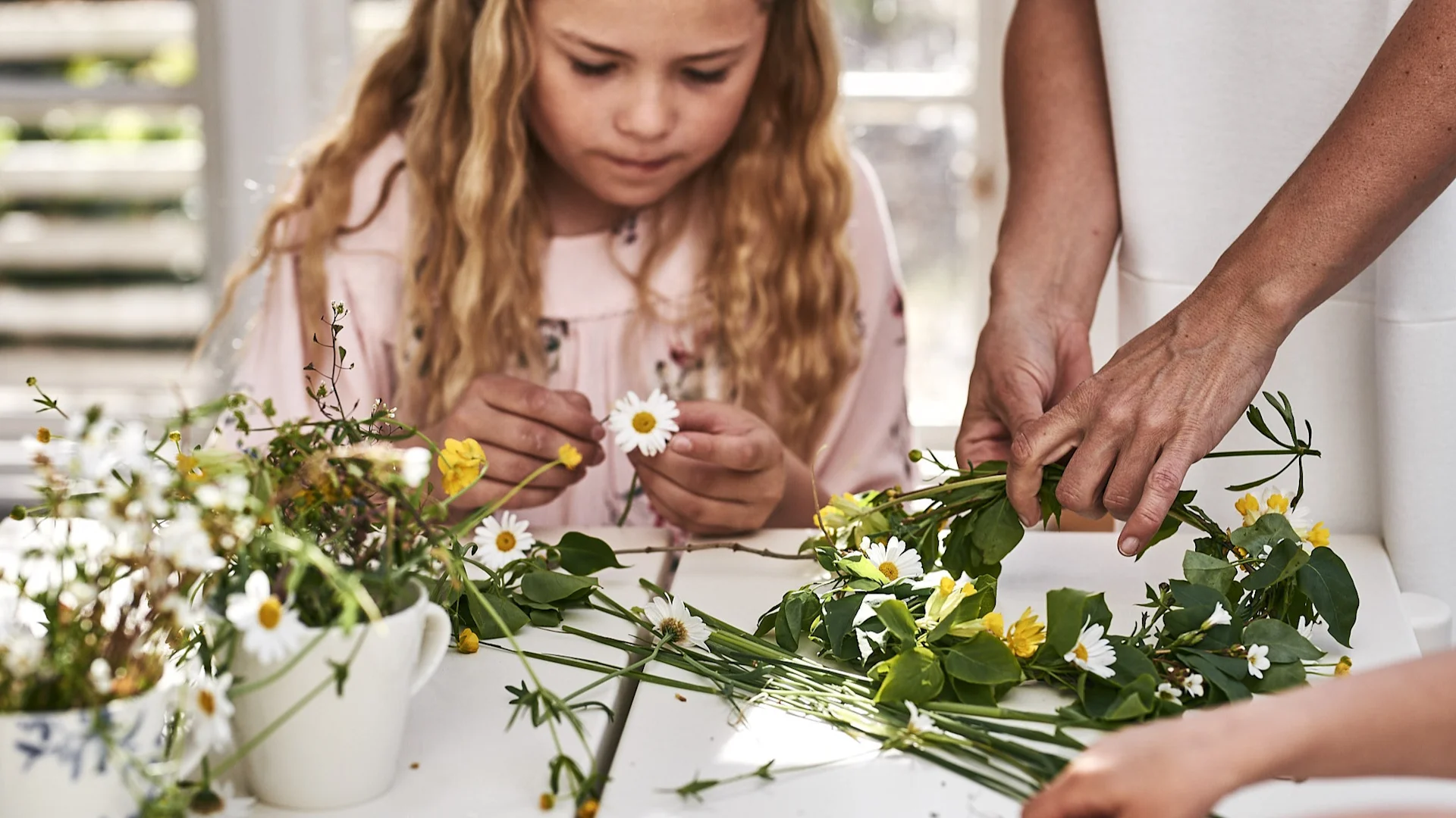 Midsommarkransen binds i växthuset med ängsblommor för ett traditionsenligt midsommarfirande.