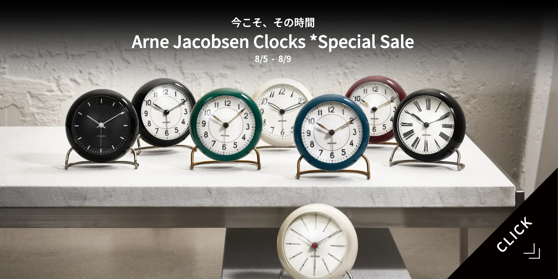 Olika färgade Arne Jacobsen skrivbordsklockor på en ljus yta, som annonserar en specialrea från 5 till 9 augusti.