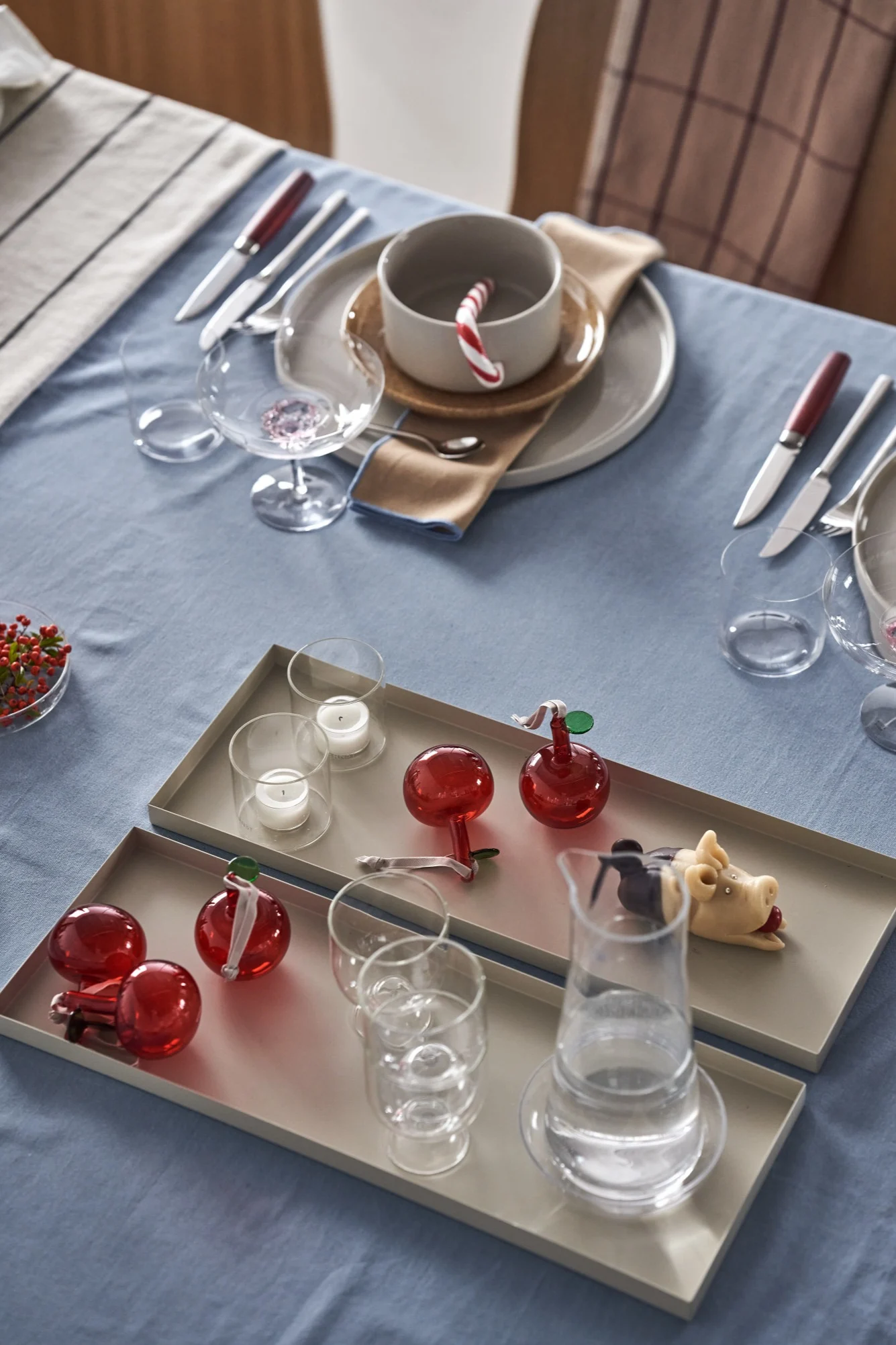 En elegant juldukning i 4 olika stilar enligt Nest Trends; Cultivate, Nurture, Boost och Share. Här är en dukning inom Share-trenden med beigea brickor från Cooee Design med Iittala glasäpplen i rött som dekoration.