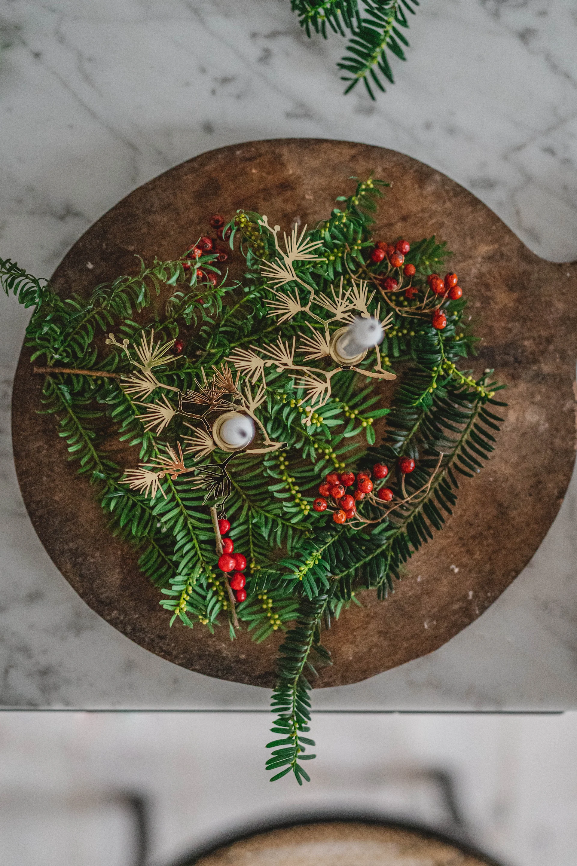 Granris pyntat med Plutos Tall ljusstakar i guld hemma hos Hannes Mauritzson. 